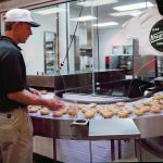 Employee watches the production line at the nation’s first Krispy Kreme donut shop in Winston-Salem, North Carolina